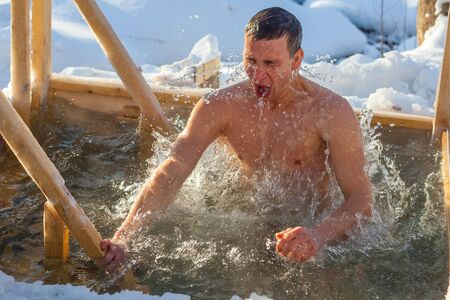 Young man haves bath in the icy waterの写真素材