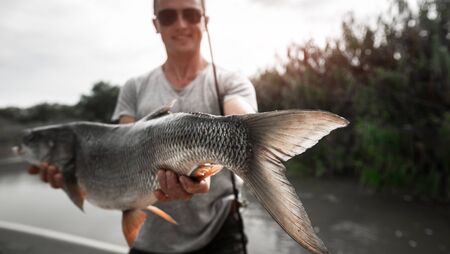Angler stands in the boat and holds the trophy Asp fishの写真素材