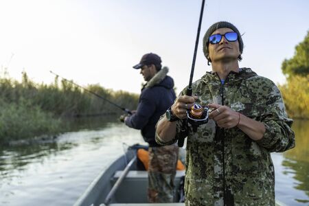 Anglers in the boat on the riverの写真素材