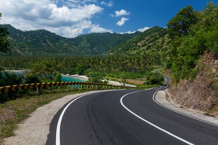Scenic asphalt road along the coastline of the island of Lombok in Indonesiaの写真素材