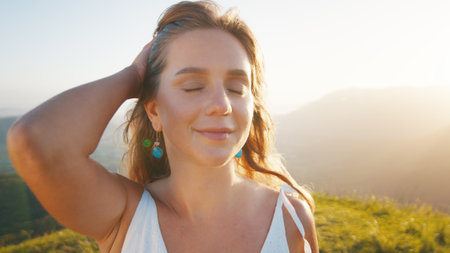 Portrait of the young caucasian woman outdoor at sunrise. Model looks into the cameraの写真素材