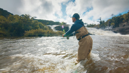 Fly fishing. Fisherman in waders fishing on the rapid riverの写真素材