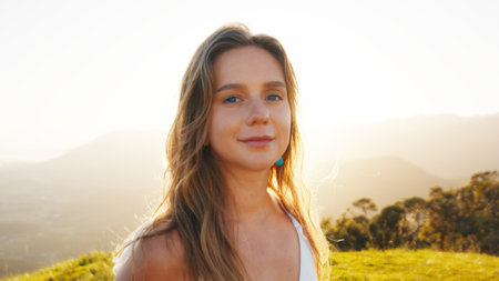 Portrait of the young caucasian woman outdoor at sunrise. Model looks into the cameraの写真素材