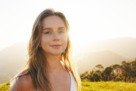 Portrait of the young caucasian woman outdoor at sunrise. Model looks into the cameraの写真素材