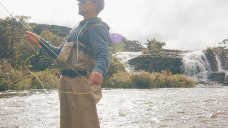 Fly fishing. Fisherman in waders fishing on the rapid riverの写真素材