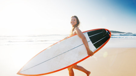 Woman surfer walks with surfing board on the tropical beachの写真素材