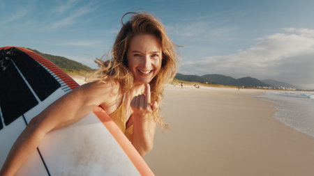Woman surfer walks with surfing board on the tropical beachの写真素材