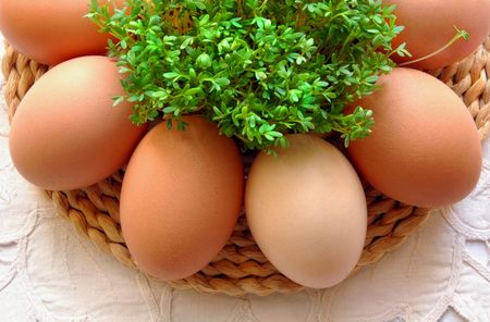 Eggs and fresh cress on straw wicker mat