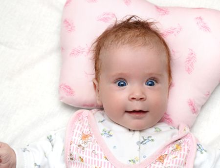 smiling newborn baby girl on pillow close-up