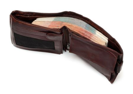brown purse with thick batch of banknotes isolated on whiteの写真素材