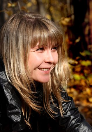 portrait of beautiful smiling young girl in autumn parkの写真素材