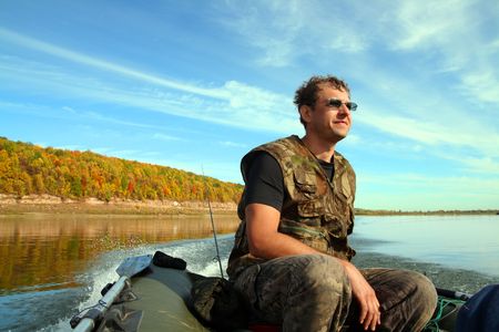 fishing man on inflatable rubber boat with motorの写真素材