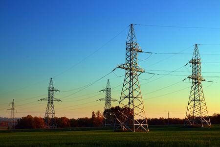 sunset landscape with electricity cable communication towersの写真素材