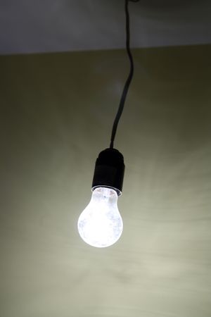 lighting dirty electrical lamp hanging on cableの写真素材