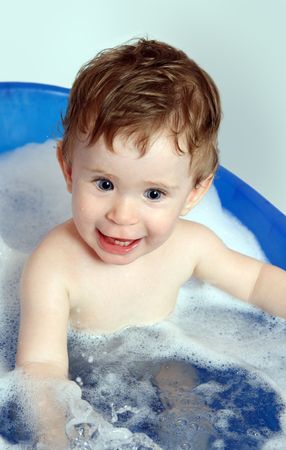 happy smiling baby bath in blue bathtub