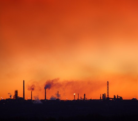 environment pollution - red sky over petrochemical factory chimneysの写真素材