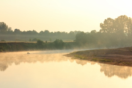 fishing on river in fog - morning landscapeの写真素材