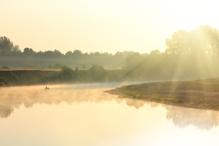 fishing on river in fog - morning landscapeの写真素材