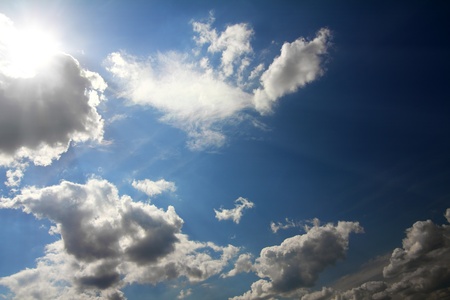 dramatic scene with clouds and sun on blue skyの写真素材