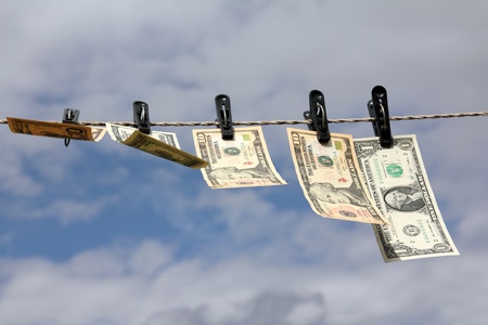 paper dollars are drying on rope under blue skyの写真素材