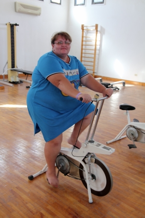 overweight woman exercising on bike simulatorの写真素材