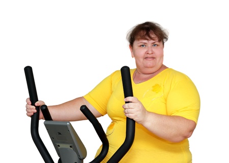 overweight woman exercising on trainer ellipsoidの写真素材