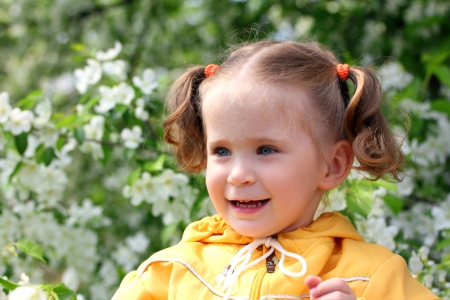 happy little girl near blossoming apple tree at springの写真素材