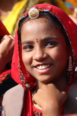 PUSHKAR, INDIA - NOVEMBER 21 2012: Portrait of smiling Indian girl in colorful ethnic attire at Pushkar camel fairのeditorial素材