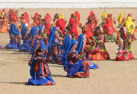 PUSHKAR, INDIA - NOVEMBER 21 2012: Indian girls in colorful ethnic attire dancing at Pushkar camel fairのeditorial素材