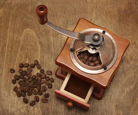 vintage coffee grinder and beans on old wooden backgroundの写真素材