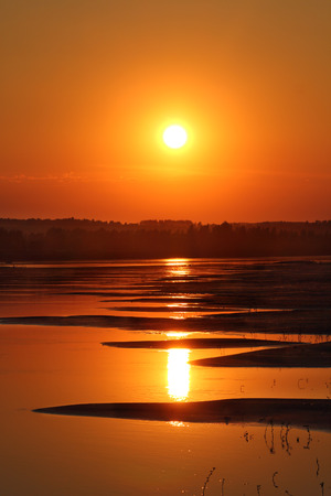 beautiful orange sunset with waved river sand beachの写真素材
