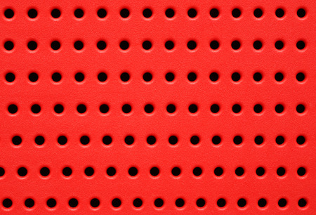 red perforated plastic background closeupの写真素材