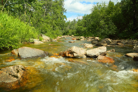 landscape with mountain river flowing over rocks at summerの写真素材