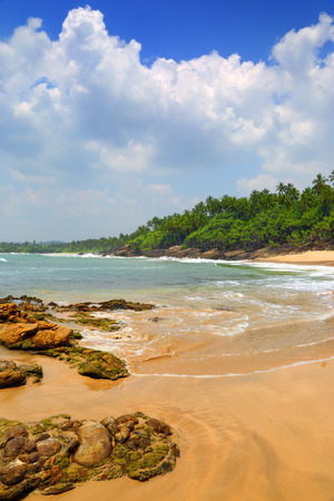 beautiful landscape with sea waves on tropical beach with stones and rocksの写真素材