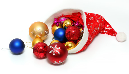 Bright christmas balls, toys in the red hat of Santa Claus on white backgroundの写真素材