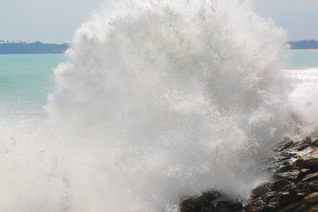 Large ocean wave breaking on the rocks of tropical coast
の写真素材