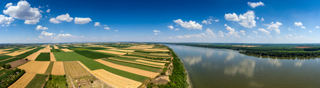 Aerial panorama of colorful fields on high bank of Danube river in Serbiaの写真素材