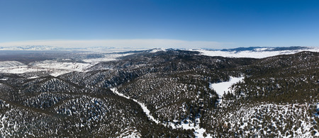 Aerial panorama view of the snow-capped Atlas mountains covered with forest in Morocco at winterの写真素材
