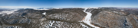 Aerial panorama view of the snow-capped Atlas mountains covered with forest in Morocco at winterの写真素材