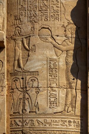 Hieroglyphic carvings on the exterior walls of an ancient egyptian templeの写真素材