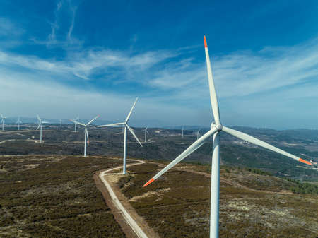 Aerial view of lot of windmills or wind turbine on wind farm in rotation to generate electricity...
