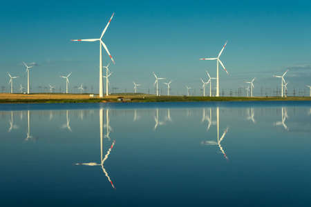 Windmills turbines with water reflectionの写真素材