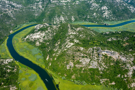 Aerial view of Rijeka Crnojevica - boats on beautiful river between mountains flowing into Skadar...