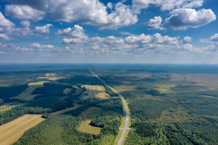 Aerial top view landscape with a country road in the forest at summerの写真素材