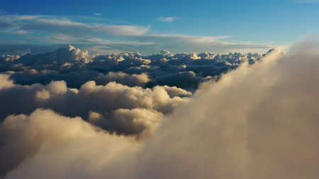 Flying above the clouds. Aerial view of clouds at sunrise. Traveling by air perfect background
