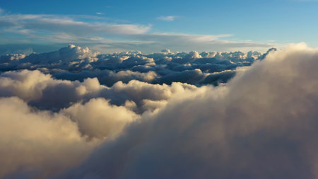 Flying above the clouds. Aerial view of clouds at sunrise. Traveling by air perfect background