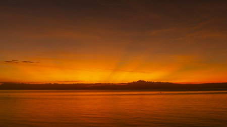 Stunning sunset over calm ocean waters with vibrant colors illuminating the sky