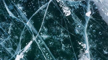 Aerial top view of frozen Lake Baikal. Blue transparent clear smooth ice with deep cracks. Famous...