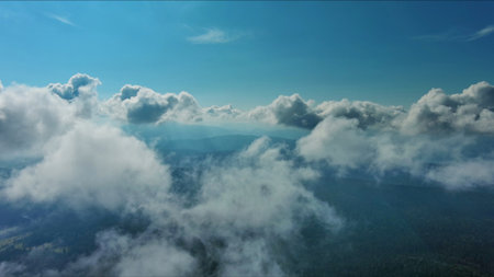 Aerial high view of clouds and mountains, flying in clouds