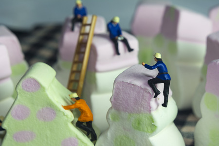 People climbing mini candies and sweetsの写真素材